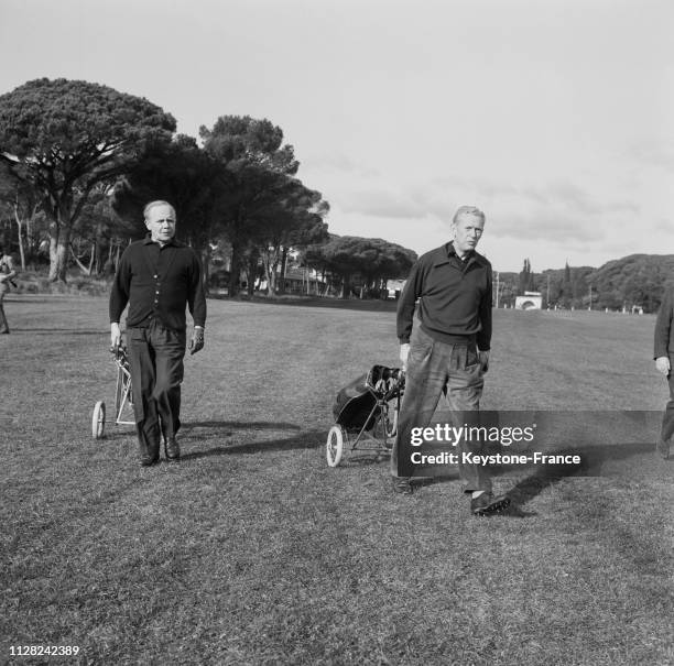 Maurice Couve de Murville arrivant sur le terrain de golf de Valescure, tirant ses cannes, à Saint-Raphaël, France, le 25 décembre 1968.