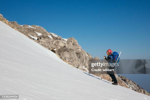 女性登山は標高の高い山のピークの冬期登山します。 - ice pick ストックフォトと画像