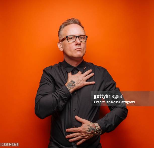 middle-aged businessman on orange background - thin man stock pictures, royalty-free photos & images