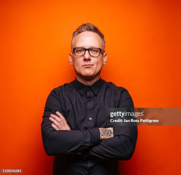 middle-aged businessman on orange background - thin man stock pictures, royalty-free photos & images