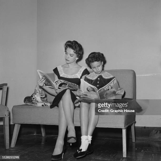American actress Natalie Wood and he sister Lana Wood reading magazines in the dressing room of a clothes shop, US, 4th January 1956.