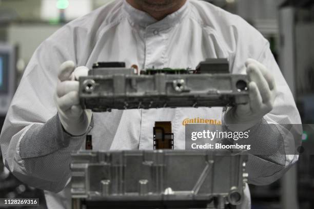 An employee assembles a DC/DC converter component for hybrid and electric vehicles inside the Continental AG automotive powertrain factory in...
