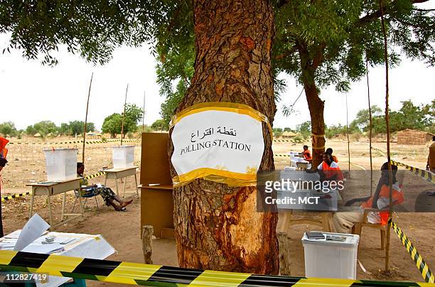 Crumpled sign taped haphazardly around a tree outside Terekeka, southern Sudan, indicates the location of one empty polling station on April 11. The...