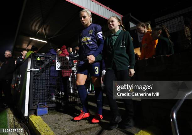 Alex Greenwood of Manchester United leads the team out with a mascot prior to the FA WSL Continental Tyres Cup semi final between Arsenal Women and...