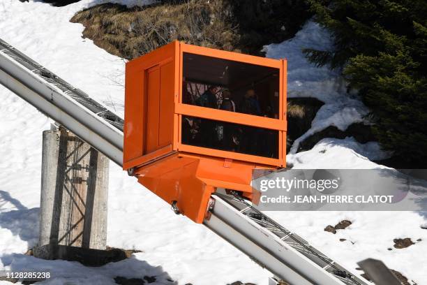 People stand in a slope lift designed in 1976 by Hungarian-born architect Marcel Breuer, on February 28, 2019 at the ski resort of Flaine,...