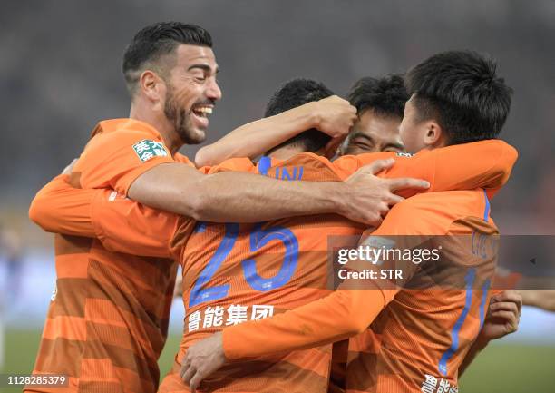Graziano Pelle , Marouane Fellaini and Liu Yang of Shandong Luneng celebrate during the Chinese Super League football match between Shandong Luneng...