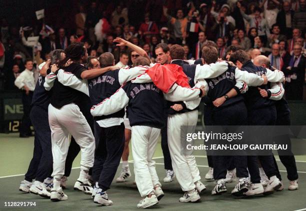 French tennis team dances after winning the Davis Cup final match between Arnaud Boetsch and Nicklas Kulti here 1 december 1996 at Malmomassen...