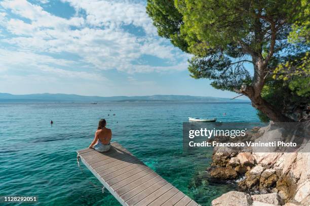 woman by the sea, brac island, croatia. - ardia stock-fotos und bilder