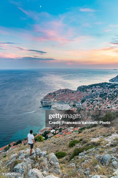 man watching the sunset from uphill, dubrovnik, croatia. - dubrovnik old town stock pictures, royalty-free photos & images