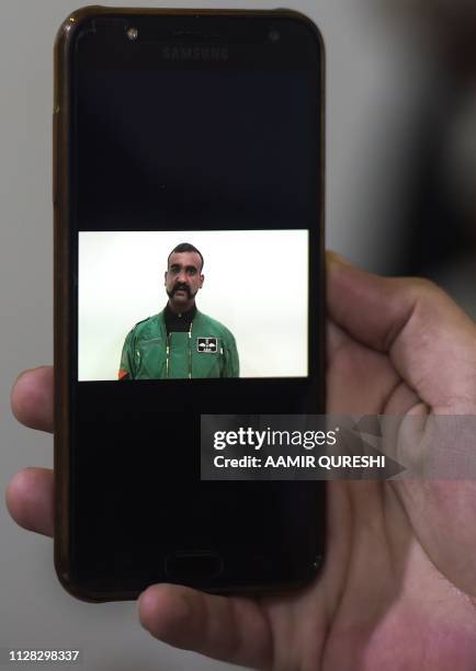 Pakistani man watches the latest video statement released by Pakistan's military authorities of the Indian Wing Commander pilot Abhinandan Varthaman...