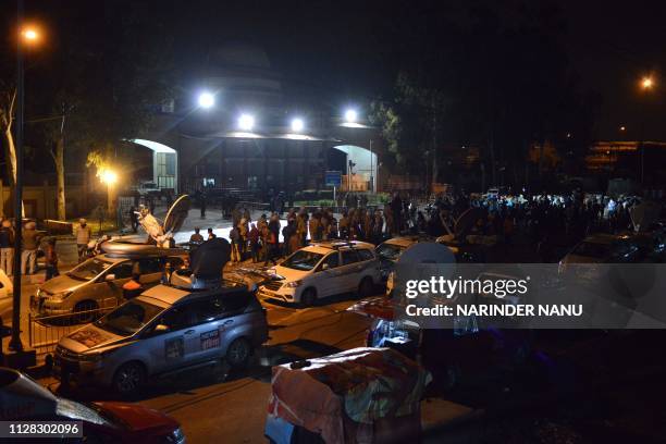 Indian policemen and media personnel wait for the return of Indian pilot Indian Air Force Wing Commander Abhinandan Varthaman outside the Integrated...