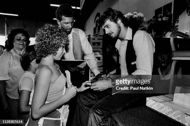 American Country musician and actor John Schneider signs an autograph for a fan during an event to promote his self-titled debut album at an...