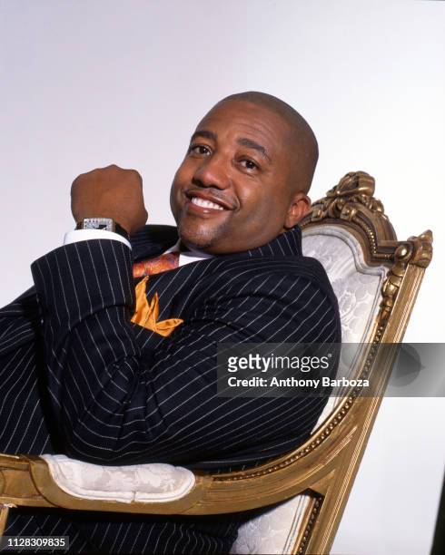 Portrait of American record executive Kevin Liles, in a pin-stripe suit, as he sits in an armchair, New York, 1990s.