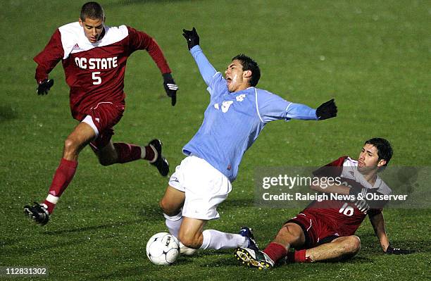 State's Alan Sanchez trips up North Carolina's Michael Farfan as State's Farouk Bseiso attempts to gain control of the ball on Wednesday, November 11...