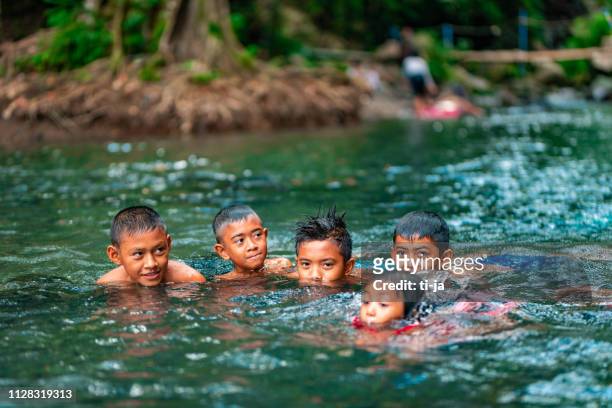 indonesian children playing in the river - asia village river stock pictures, royalty-free photos & images