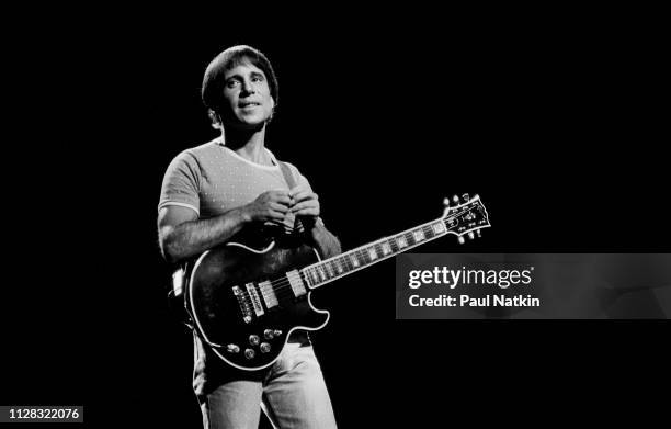 American Folk and Pop musician Paul Simon plays guitar as he performs onstage at the Auditorium Theater, Chicago, Illinois, September 25, 1980.