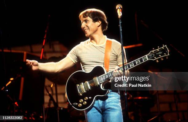 American Folk and Pop musician Paul Simon plays guitar as he performs onstage at the Auditorium Theater, Chicago, Illinois, September 25, 1980.