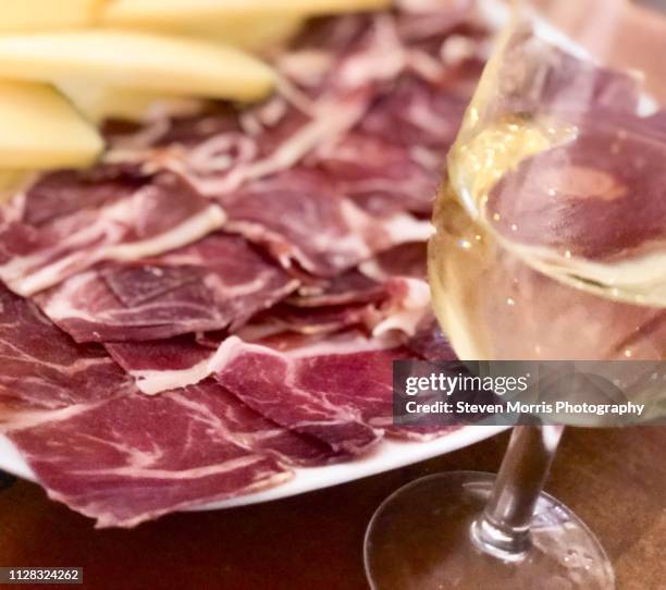 serrano ham platter with a glass of sherry - serrano ham foto e immagini stock