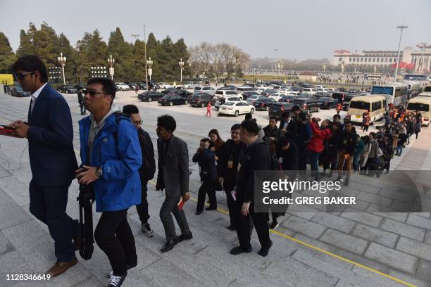 Journalist line up to enter the Great Hall of the People for a press conference for the Chinese People's Political Consultative Conference in Beijing...