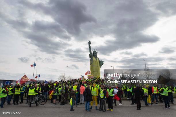Yellow Vests" protesters stand next to the Statue of Liberty replica wearing a Yellow vest as they take part in an anti-government demonstration on...