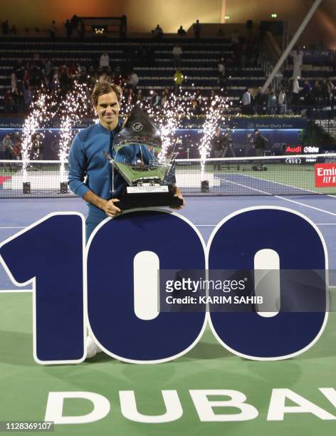 Switzerland's Roger Federer celebrates with the trophy after winning the final match at the ATP Dubai Tennis Championship in the Gulf emirate of...