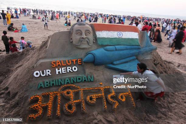 Indian sand artist Laxmi Gaud gives the finishing touch to a sand sculpture paying tribute to the return of Indian Air Force pilot Abhinandan...