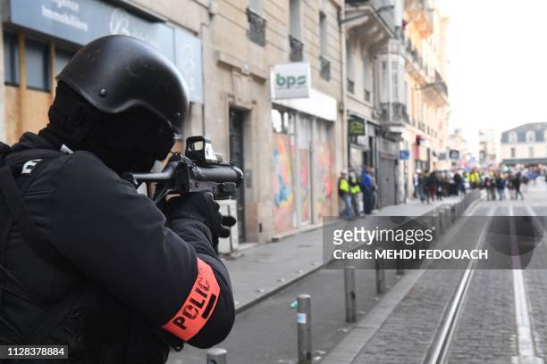 Riot police officer holds a 40-millimetre rubber defensive bullet launcher LBD weapon during an anti-government demonstration called by the "Yellow...