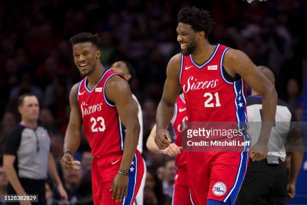 Joel Embiid and Jimmy Butler of the Philadelphia 76ers react against the Denver Nuggets at the Wells Fargo Center on February 8, 2019 in...