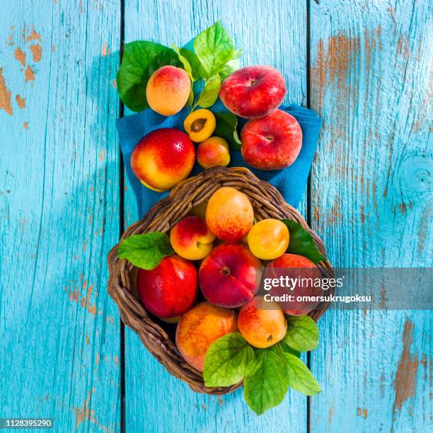 fruits d’été en panier d’osier sur vieux bleu en bois - fruits été photos et images de collection