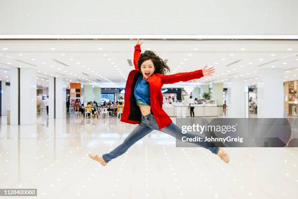 chinese woman leaping mid air in shopping mall - chinese dance stock pictures, royalty-free photos & images