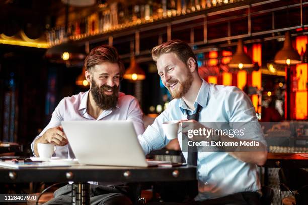 business partners having a coffee break after working on the go in a bar - cashflow stock pictures, royalty-free photos & images