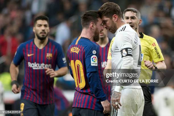 Barcelona's Argentinian forward Lionel Messi argues with Real Madrid's Spanish defender Sergio Ramos during the Spanish league football match between...