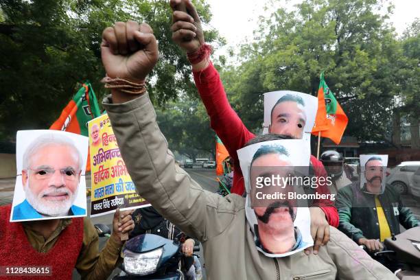People wear masks in the likeness of Indian Prime Minister Narendra Modi, left, and Indian Air Force pilot Abhinandan Varthaman during a rally in New...