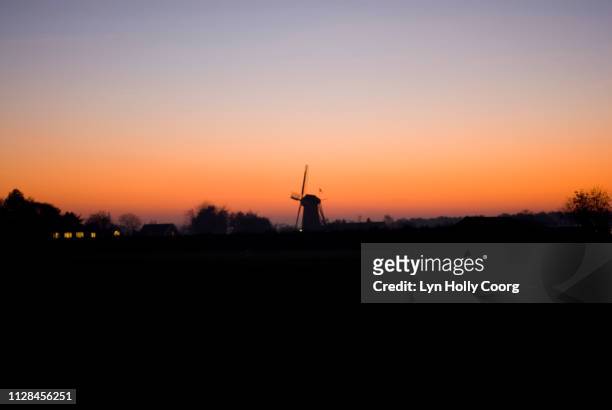 dutch windmill silhouetted against horizon at sunset - lyn holly coorg fotografías e imágenes de stock