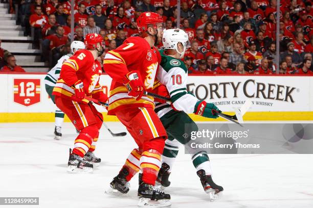 Brodie of the Calgary Flames skates against Matt Read of the Minnesota Wild during an NHL game on March 2 18, 2019 at the Scotiabank Saddledome in...