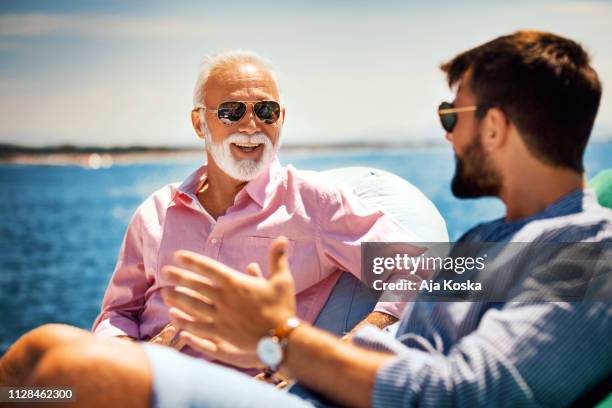 father and son bonding on the yacht cruse. - father son sailing stock pictures, royalty-free photos & images