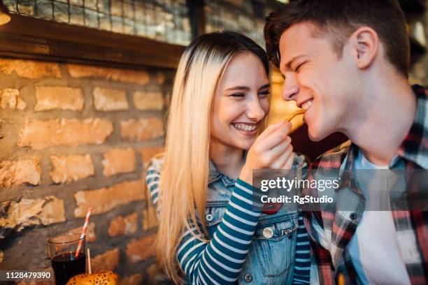 couple sharing a meal - french fries stock pictures, royalty-free photos & images