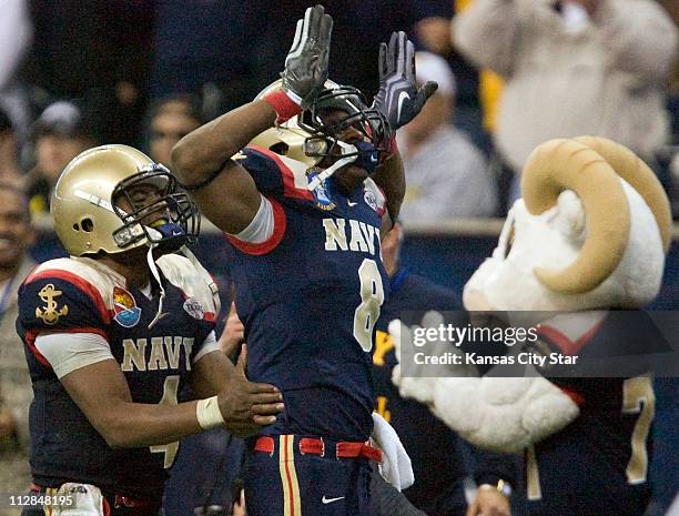 Navy safety Wyatt Middleton celebrates his interception along the sidelines with Navy quarterback Ricky Dobbs during the fourth quarter against...