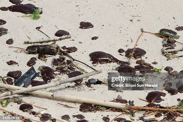 Oil-tar patties from the Deepwater Horizon oil spill cover the beach in Waveland, Mississippi, on Wednesday, July 7, 2010.