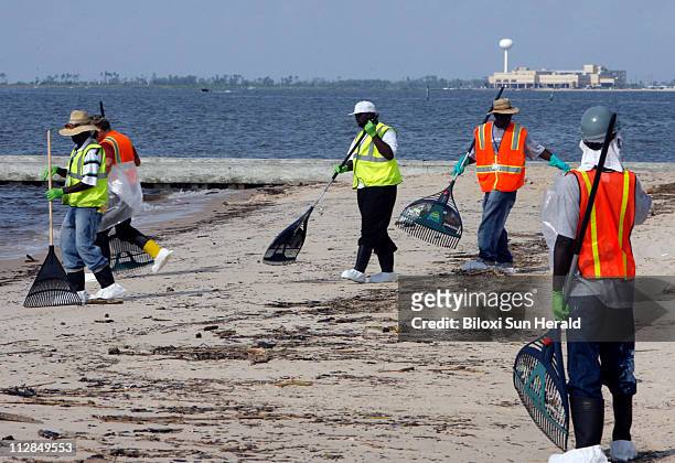 Cleanup crews begin the task of ridding the beaches of oil and tar balls in Waveland, Mississippi, Thursday, July 8, 2010.