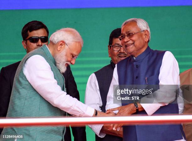 Indian Prime Minister Narendra Modi shake hands with Bihar Chief Minister Nitish Kumar during the National Democratic Alliance 'Sankalp' rally in...