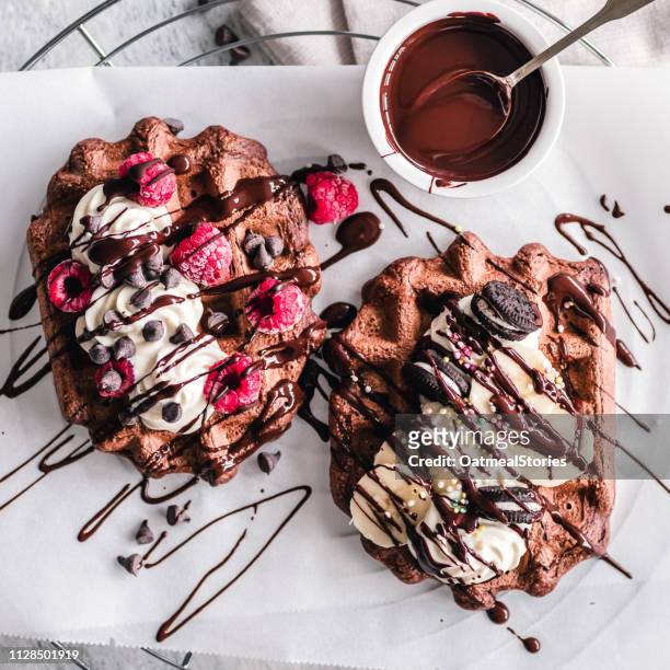 chocolate waffles with cream, chocolate sauce, fruit and chocolate sandwich cookies - chocolate sauce stock pictures, royalty-free photos & images