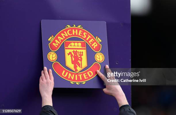 The Manchester United club badge is put up on the board during the Premier League match between Fulham FC and Manchester United at Craven Cottage on...