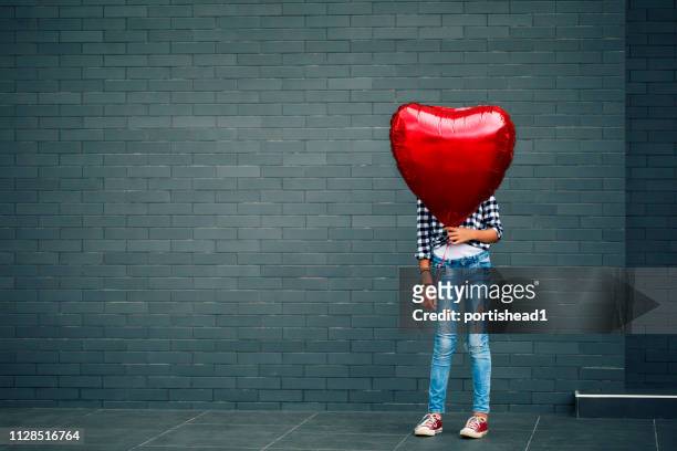 girl with heart shape balloon - heart balloon stock pictures, royalty-free photos & images