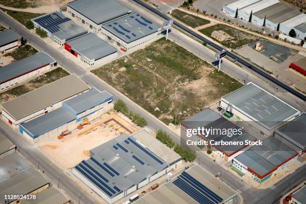 industrial buildings with solar panels on their roofs - pequeña empresa stockfoto's en -beelden