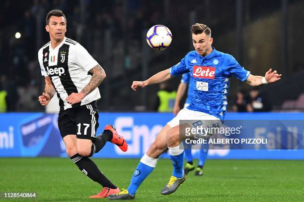 Napoli's Spanish midfielder Fabian Ruiz fights for the ball with Juventus' Croatian forward Mario Mandzukic during the Italian Serie A football match...