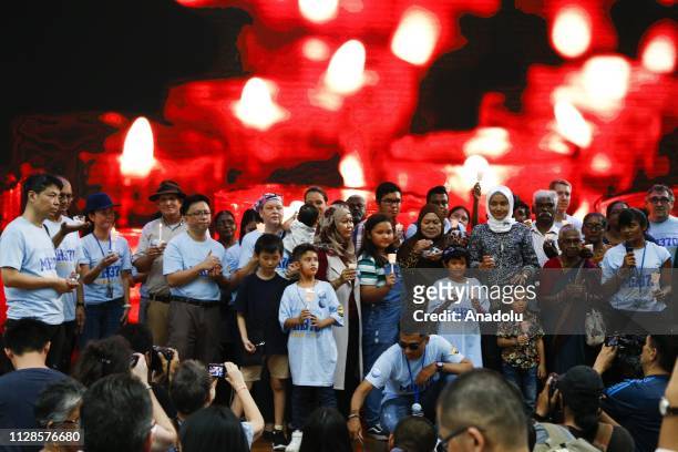 Family members hold a candles to pay tribute to missing passengers during a commemoration event to mark the 5th anniversary of the missing Malaysia...