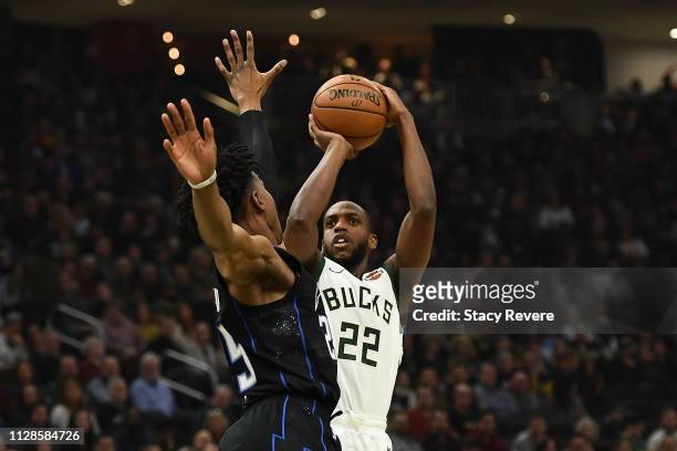 Khris Middleton of the Milwaukee Bucks shoots over Wesley Iwundu of the Orlando Magic during the first half of a game at Fiserv Forum on February 09,...