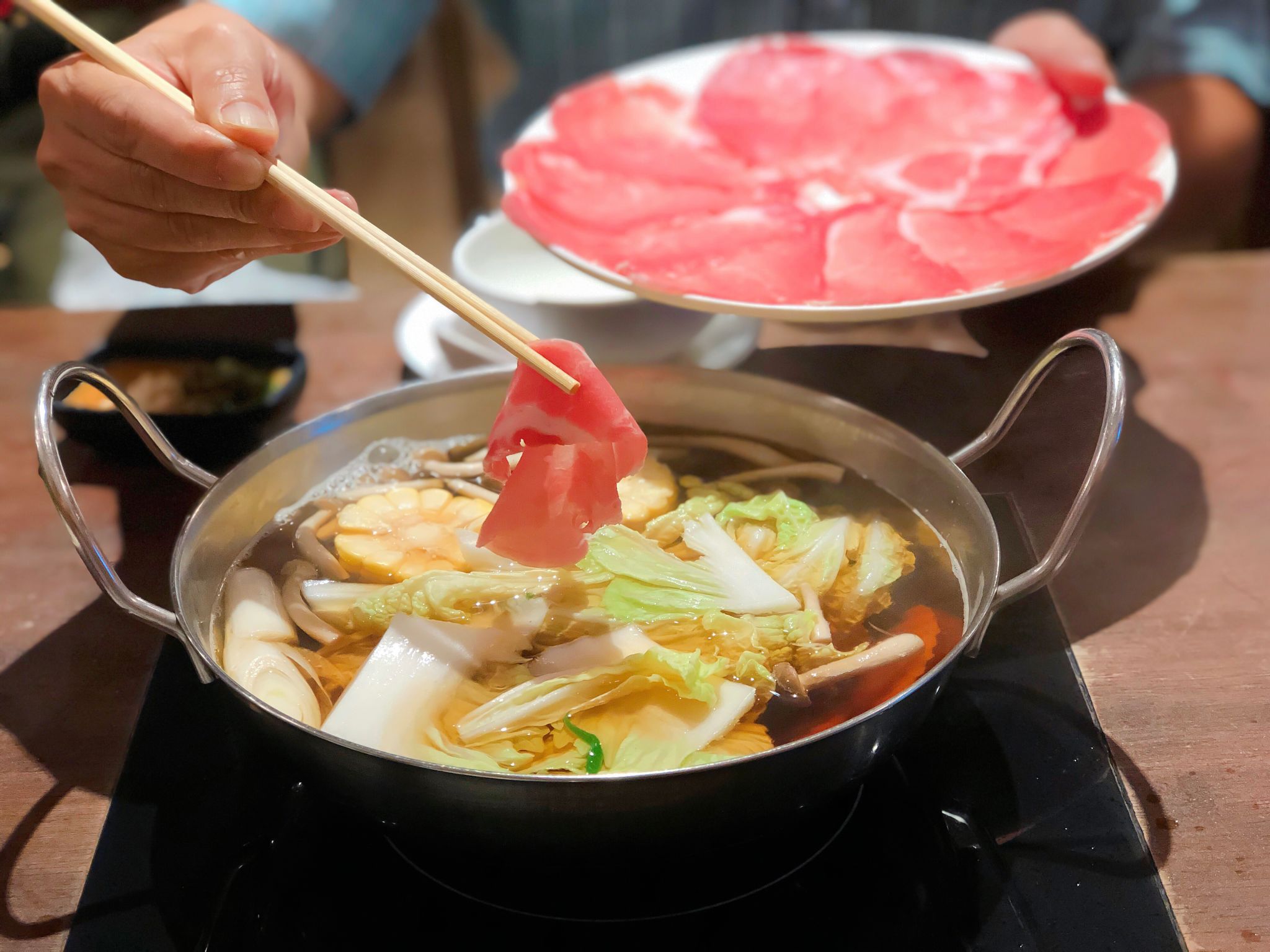 Pork shabu in hand and plate of slice kurobuta pork. Shabu or Sukiyaki hot pot is a Japanese style and Korean style. Rice, sausage and garlic, Delicious shabu shabu in a bowl, healthy food Pork shabu in hand and plate of slice kurobuta pork. Shabu or Sukiyaki hot pot is a Japanese style and Korean style. Rice, sausage and garlic, Delicious shabu shabu in a bowl, healthy food