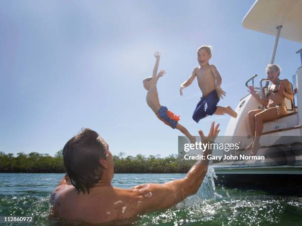 kids jumping in the water from yacht - family yacht stock pictures, royalty-free photos & images